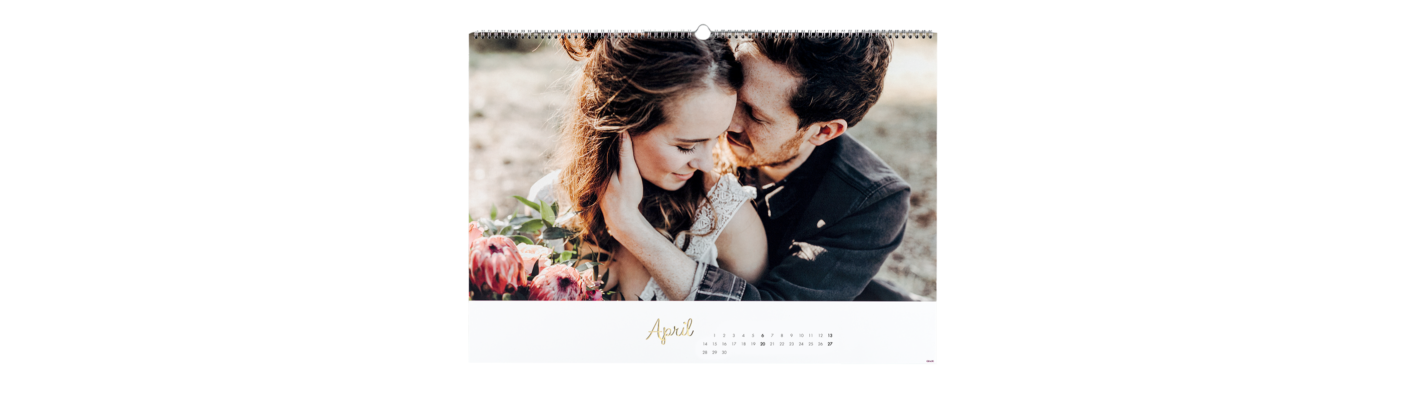 Ein Paar sitzt eng umarmt am Strand und genießt einen romantischen Moment. Sie halten einen bunten Strauß Blumen, der ihre Liebe symbolisiert.