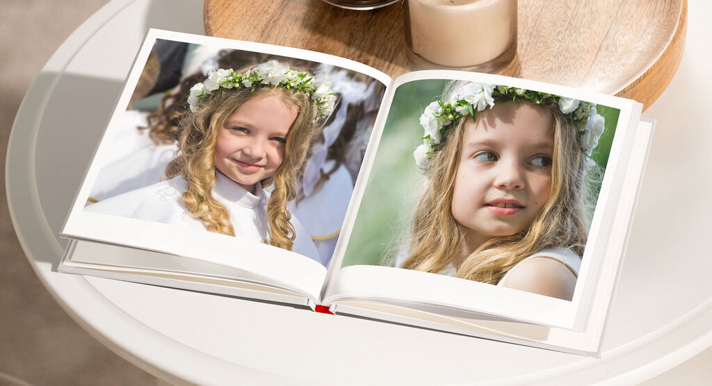 Aufgeschlagenes CEWE FOTOBUCH mit zwei Bildern von einem feierlichen Anlass