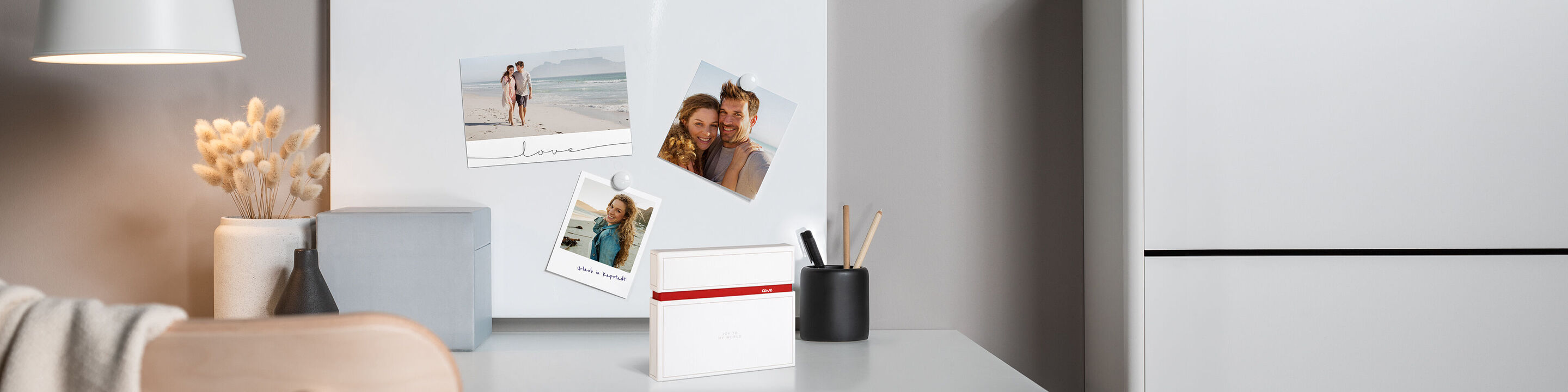Ein schöner Arbeitsplatz mit Familienfotos auf einer Magnettafel
