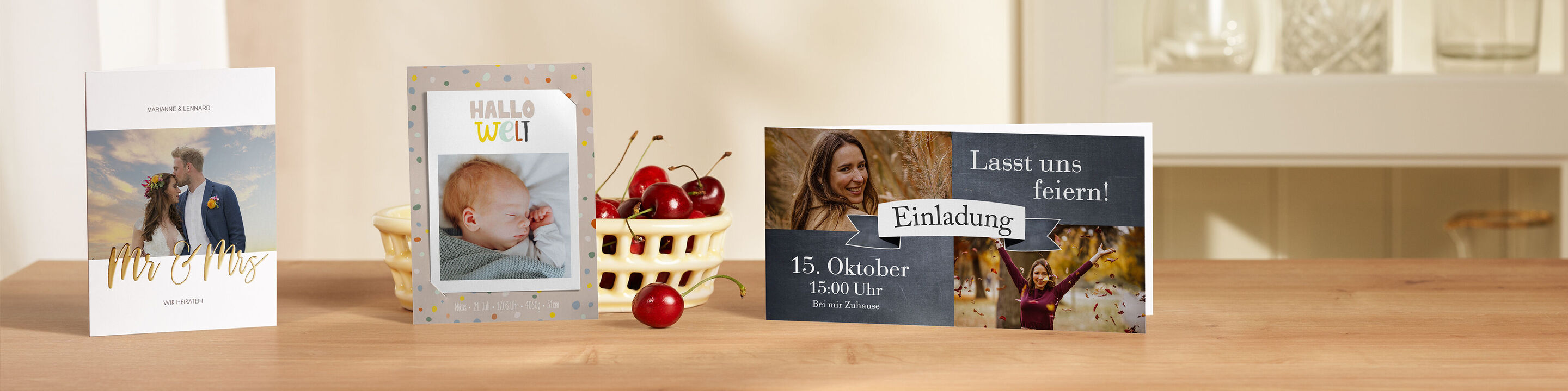 Drei liebevoll gestaltete CEWE Grußkarten stehen auf einem Tisch. Eine Karte zeigt ein Bild einer Familie, die andere ein Babyfoto und die dritte ist für eine Einladung.