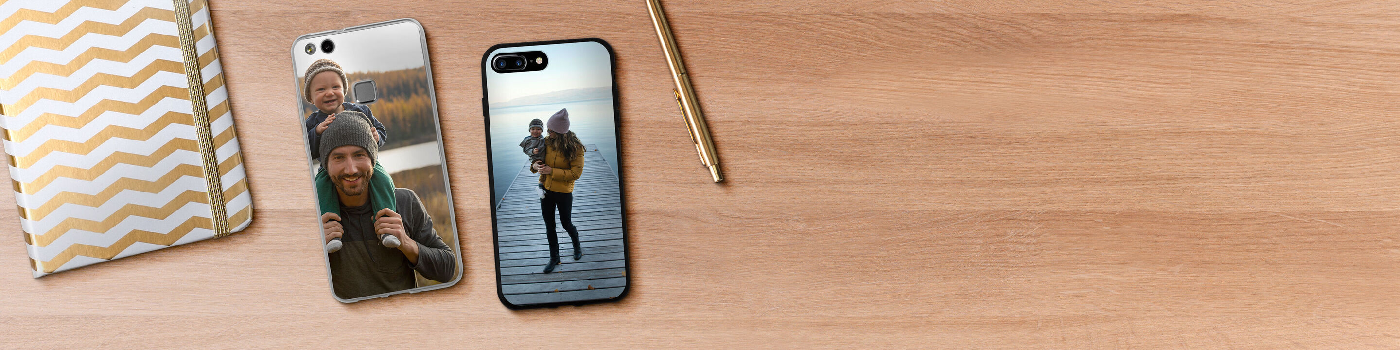 Zwei personalisierte Handyhüllen mit Fotos, auf einem Holztisch mit einem Goldstift und einem Notizbuch.
