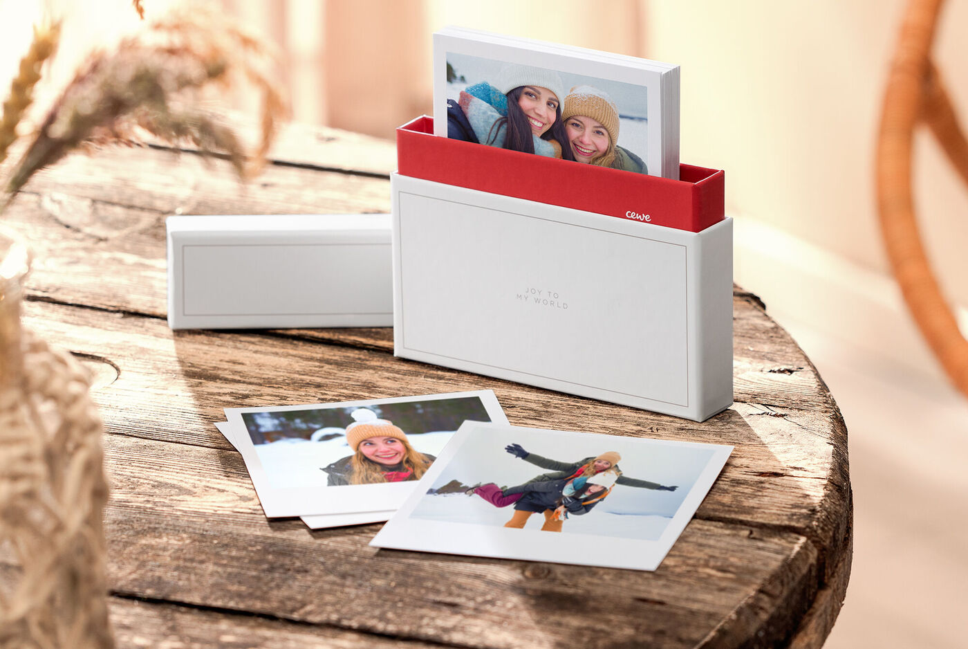 Stylische Foto-Box mit schönen Erinnerungsfotos auf einem Holztisch
