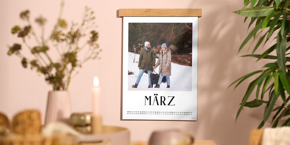 Ein CEWE Fotokalender Fineline zeigt zwei Menschen, die im winterlichen Schnee fröhlich nebeneinander gehen.