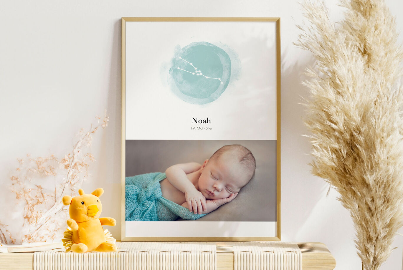 Ein süßes Baby schläft friedlich in einem bunten Tuch. Neben dem Baby befindet sich ein niedlicher gelber Teddybär auf einer Holzplatte. Im Hintergrund ist eine sanfte, moderne Dekoration zu sehen.