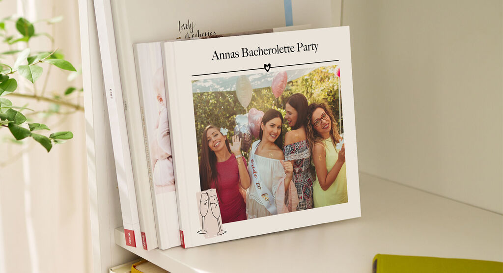 Ein CEWE FOTOBUCH von Annas Bachelorette Party, mit der Feier im Freien und festlich gekleideten Frauen auf der Vorderseite