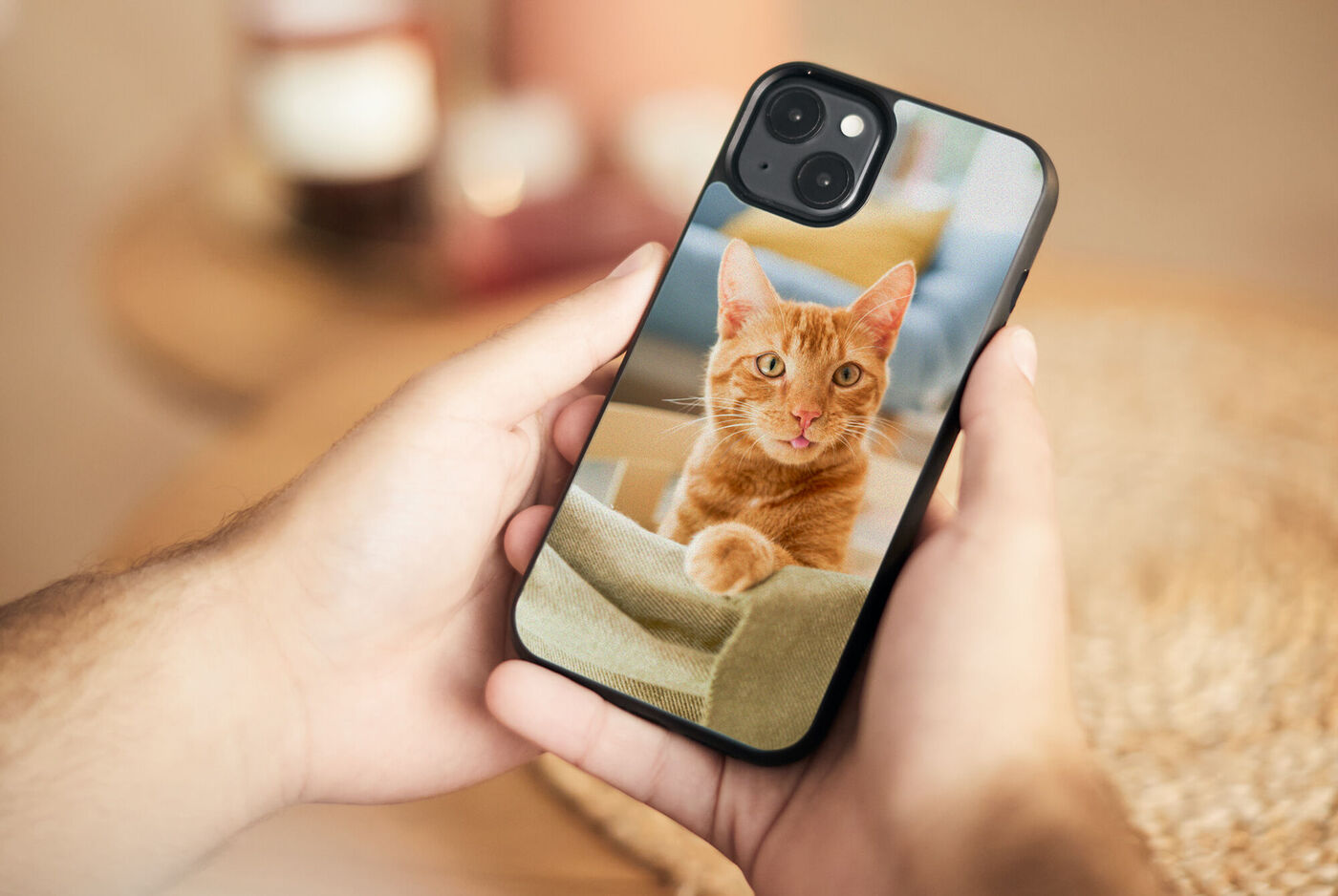 Eine Person hält eine Smartphone‑Hülle mit einem Foto einer roten Katze in der Hand.