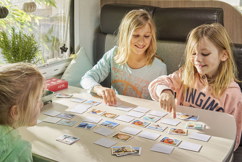 Kinder spielen ein Erinnerungsspiel mit Bildern, das ihre Lieblingsmomente zeigt