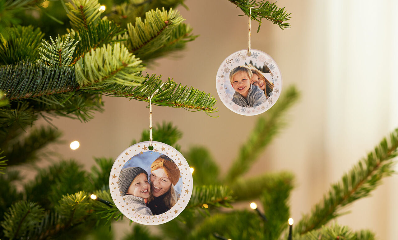 Zwei runde Fotos schmücken einen Weihnachtsbaum.
