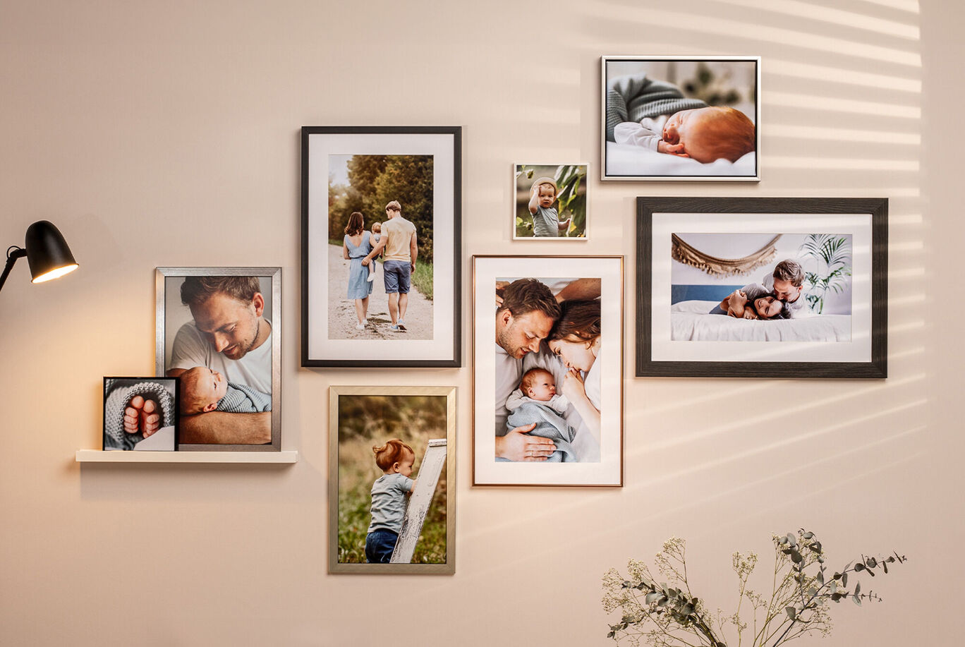 Ein liebevoll gestaltetes CEWE Wandbild mit Familienfotos in bunten Rahmen an einer Wand.