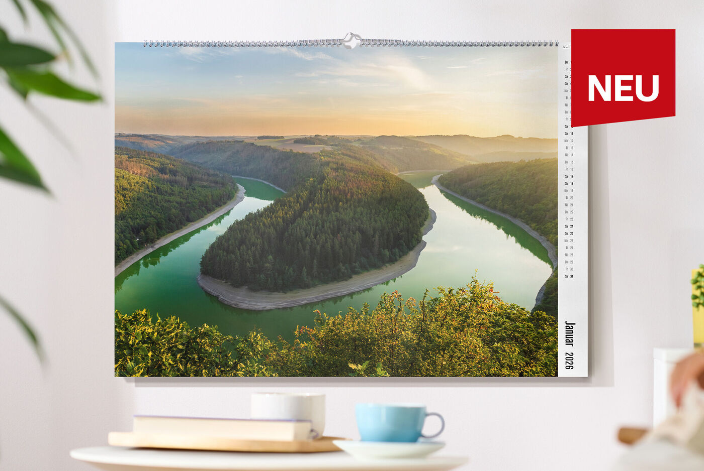 CEWE Fotokalender mit Landschaftsbild hängt an einer weißen Wand
