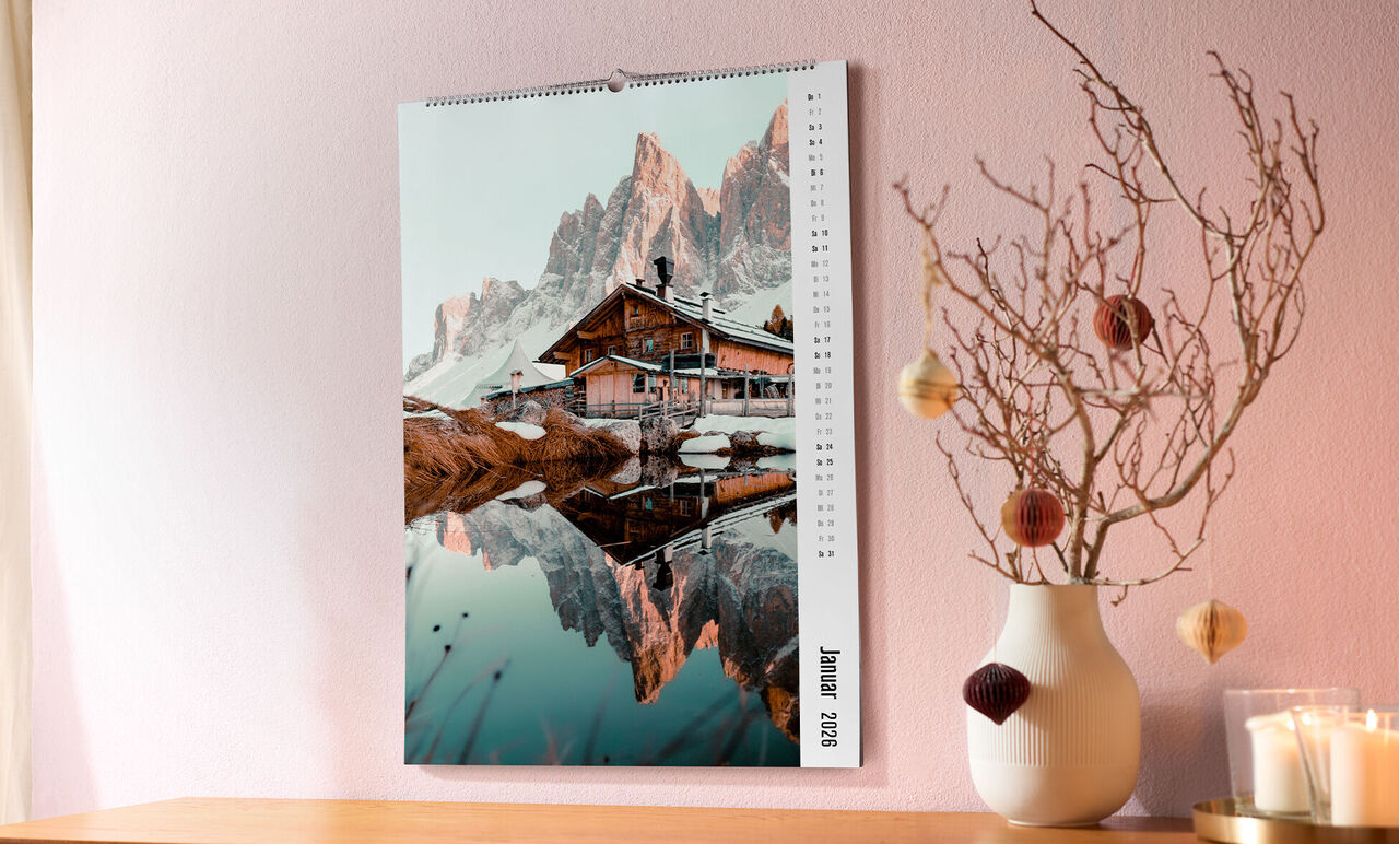 Ein wunderschöner Fotokalender zeigt ein reflektierendes Haus in den Bergen. CEWE Fotokalender.
