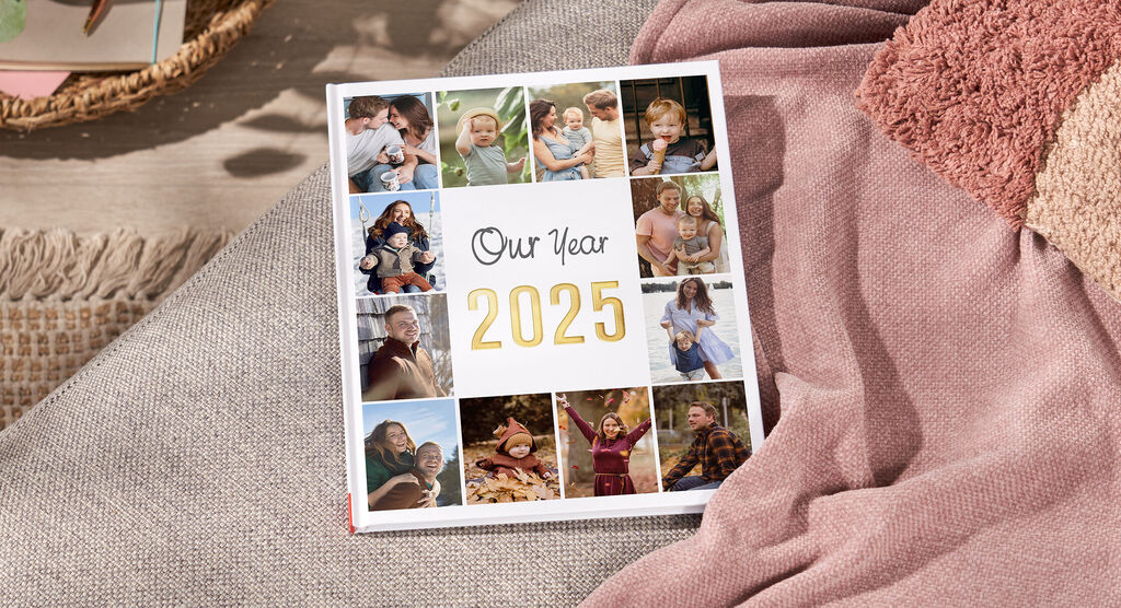 Ein liebevolles CEWE FOTOBUCH mit persönlichen Erinnerungen für das Jahr 2024, umgeben von einer gemütlichen Decke und Accessoires