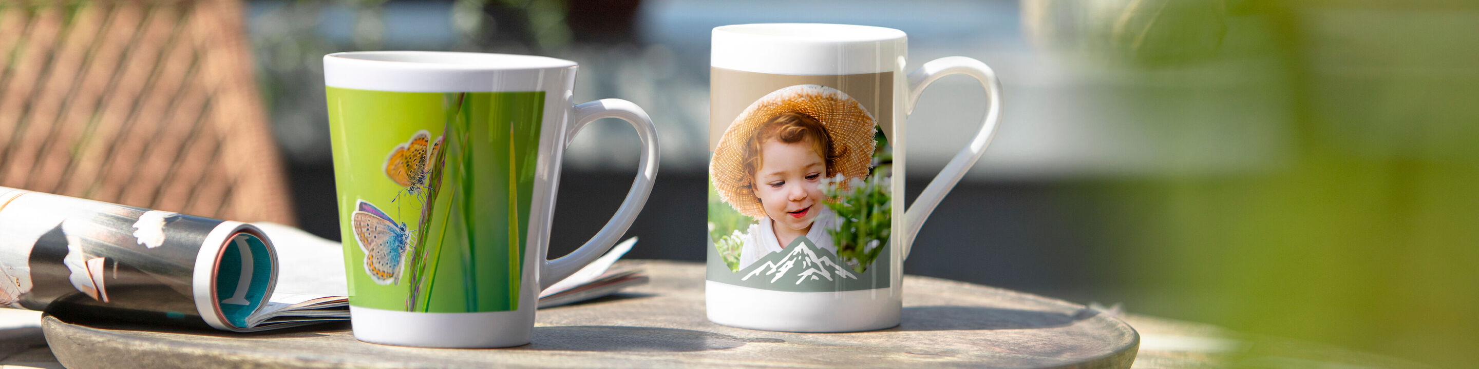 Zwei wunderschöne Tassen mit individuellen Fotos und Motiven auf einem Holztisch