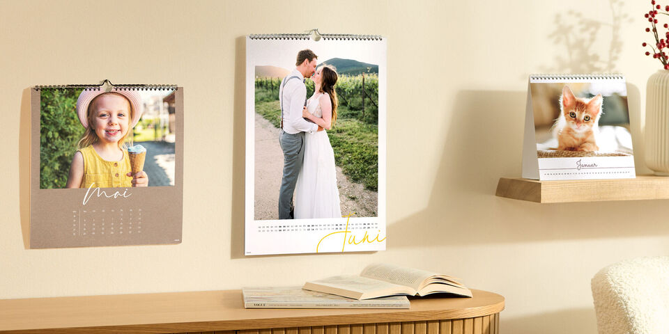 Zwei kreative Fotokalender mit bezaubernden Bildern. Ein Kalender zeigt eine fröhliche Person und der andere einen süßen Kater.