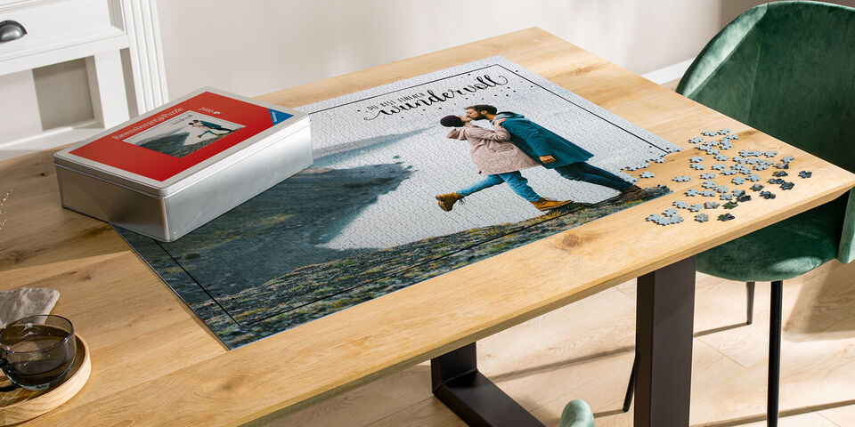 Ein Paar küsst sich vor einer aus dem Puzzle zusammengesetzten Landschaft, mit einer Puzzle-Box an der Seite.